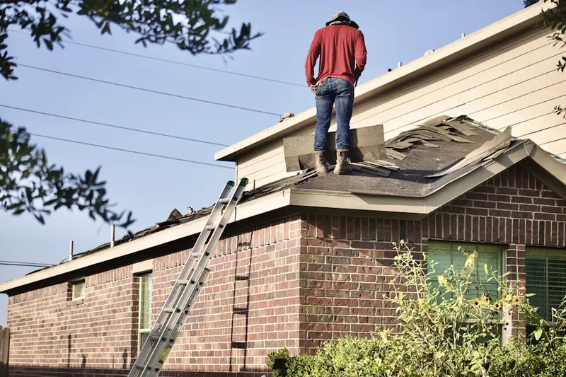 Professional roofer working on a residential roof in Pelham